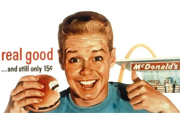50s ad depicting a person with a McDonalds burger and the title "real good...and still only 15c"